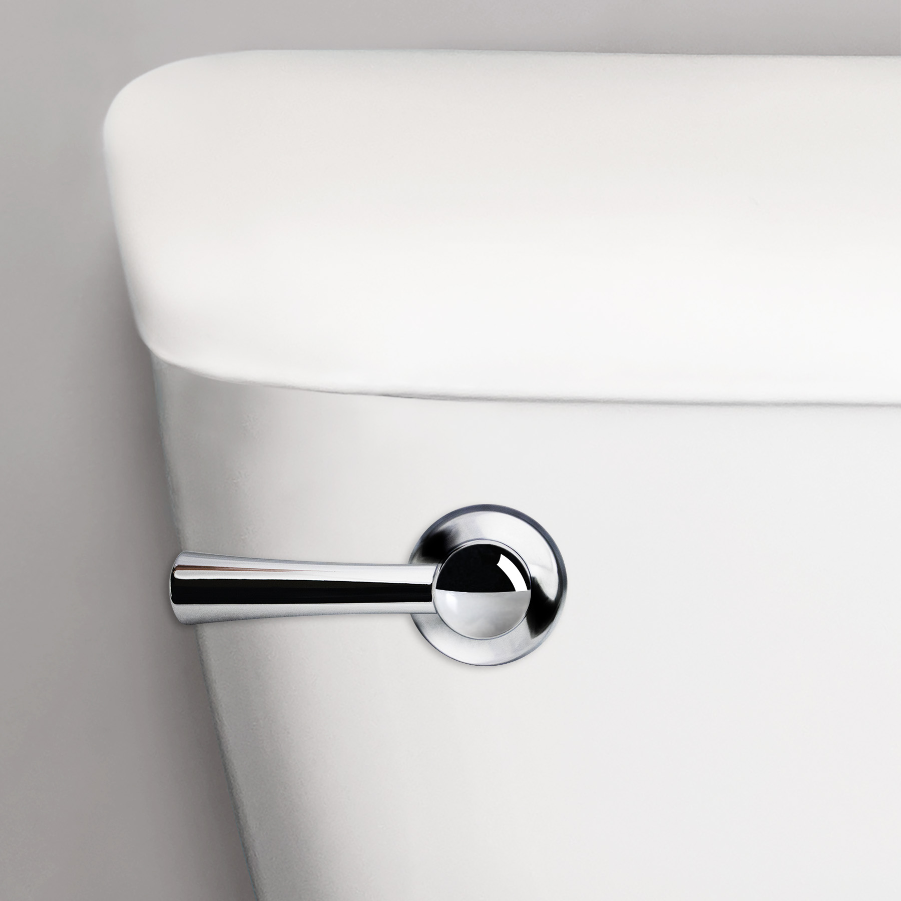 Chrome flush handle close up on a toilet tank