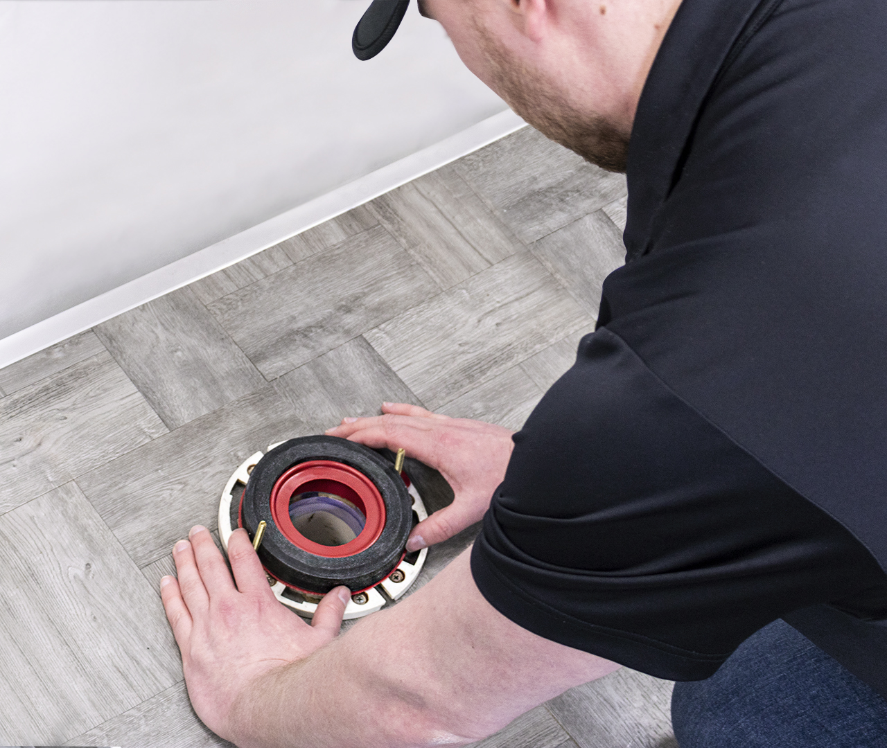 Plumber installing a wax free toilet seal